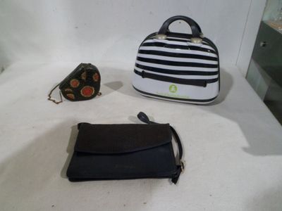 two purses and a handbag sitting on a table