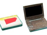 a small laptop computer sitting next to a smaller laptop computer