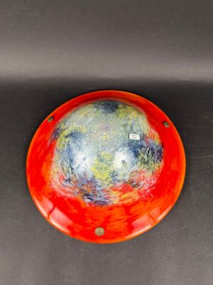 un bol orange et bleu posé sur une table noire
