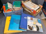 une pile de livres posée sur un canapé, à côté d'autres livres