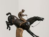 statue d'un homme à cheval, posée sur un socle dans une pièce