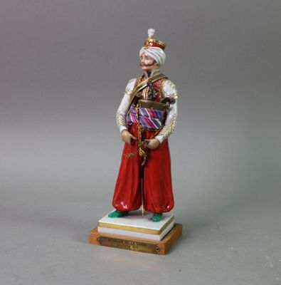 figurine of a man dressed in traditional clothing and a turban