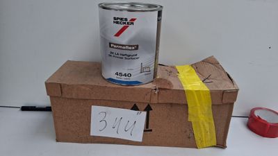 un pot de peinture posé sur une boîte en carton