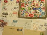 a box of stamps sitting on a table next to a bunch of postcards