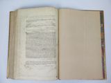 an open book on a white table with a bookmark on it
