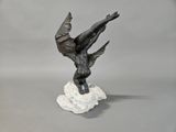statue of a bird on a rock on a gray background