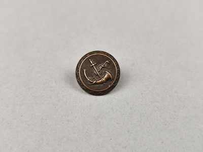 un petit bouton en bronze orné d'une ancre