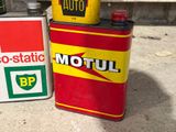 two cans of motor oil sitting next to each other on the ground