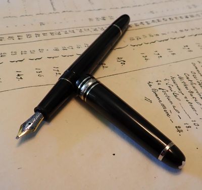 un stylo posé sur une feuille de papier sur laquelle il y a des mots écrits