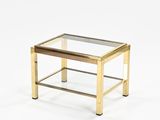 a gold coffee table with a glass top on a white background