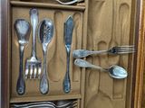 many spoons and silverware in a wooden box