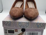 une paire de chaussures marron posée sur une boîte