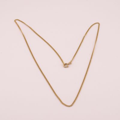 un collier à chaîne en or orné d'un seul diamant sur fond blanc