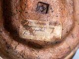 a brown vase with writing on it sitting on a table
