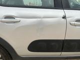 a small white car parked on the side of the road
