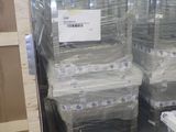 Des cartons contenant des matelas sont empilés sur des palettes dans un entrepôt