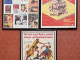 Trois affiches de cinéma encadrées sont accrochées au mur d'une salle de bains