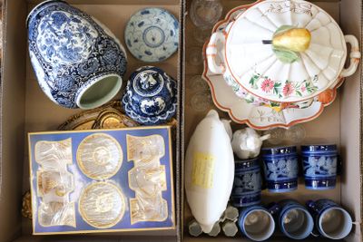 une boîte remplie de vaisselle en porcelaine bleue et blanche et d'autres objets