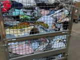 a large metal cart with a lot of clothing in it