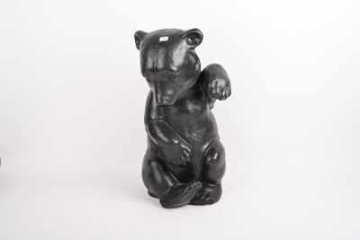 une statue d'ours noir assis sur ses pattes arrière