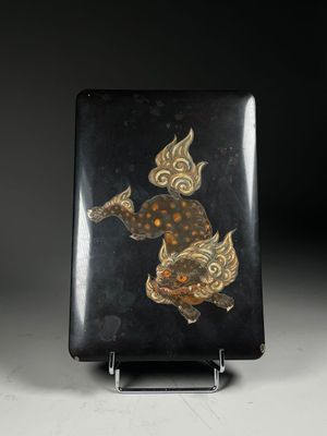 a black and gold plate with a fish design on it