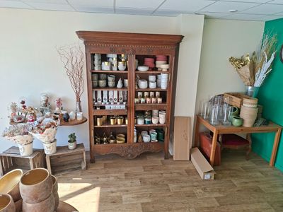 une pièce avec une armoire en bois et une étagère remplie de bocaux et de vases