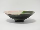 a green and pink bowl sitting on a white surface