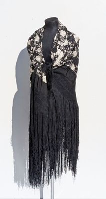 une photo d'une robe en noir et blanc à franges sur un mannequin