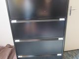 a black filing cabinet with a basket on top of it