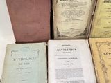 several old books are stacked on top of each other on a table