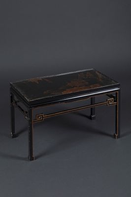 une table basse noire et dorée sur fond gris