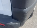 the rear end of a white van with a black bumper