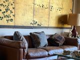 a living room with a leather couch and a large screen