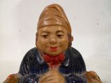 une figurine en céramique représentant un garçon assis par terre
