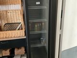 a black refrigerator with a glass door in a kitchen