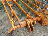 an image of a tractor plow sitting in the grass