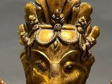 brass statue of an elephant head with a pipe in its mouth