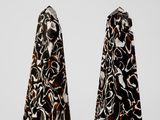 two black and white salt and pepper shakers sitting on top of each other