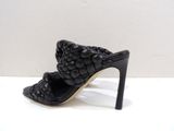 the woman is wearing a black high heeled shoe with a braid design