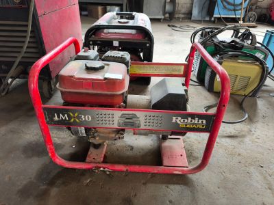 une photo d'un générateur portable rouge et noir dans un garage