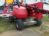 a man standing next to a red tractor with a helmet on it