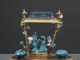 une image représentant une figurine bleue et dorée posée sur un socle