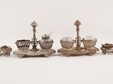 several pieces of silverware are arranged on a white surface