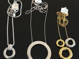 a group of three necklaces on a black surface