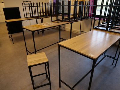 tables and stools are arranged in a room with a window in the background