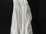 a white dress hanging on a hanger on a black background