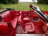 an image of a red convertible car parked in a field