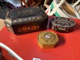 trois boîtes posées sur une table rouge