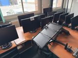 many computers on the desks in the room