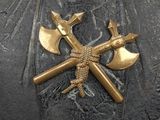 a close up of a metal object with two crossed axes on it